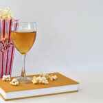 Popcorn and a wine glass on a book