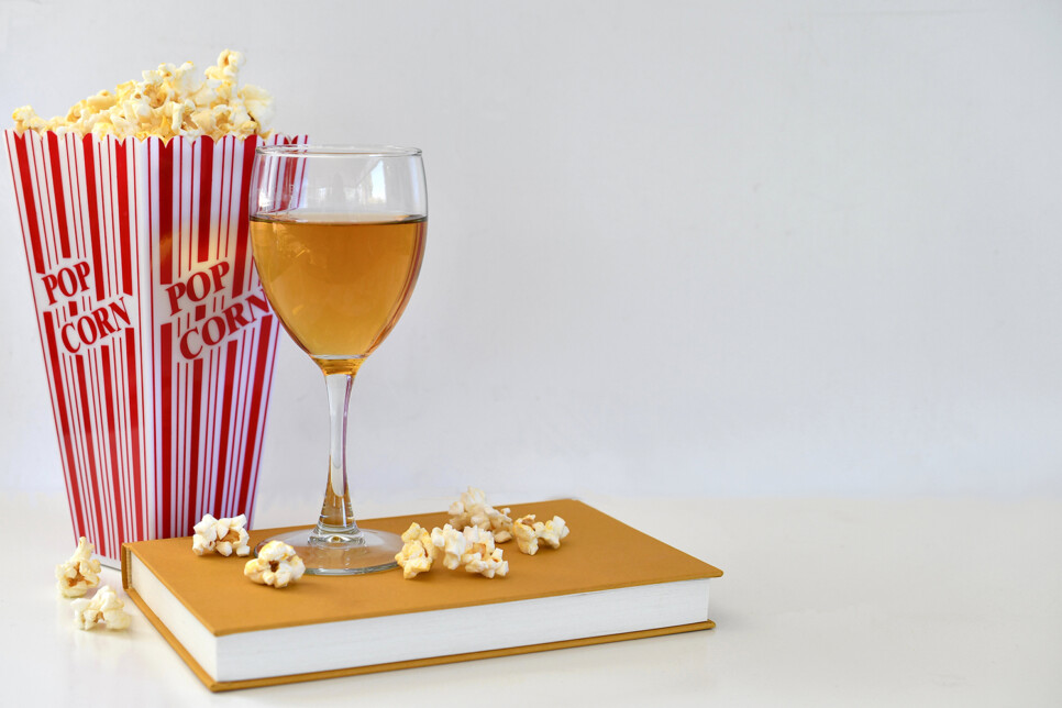 Popcorn and a wine glass on a book